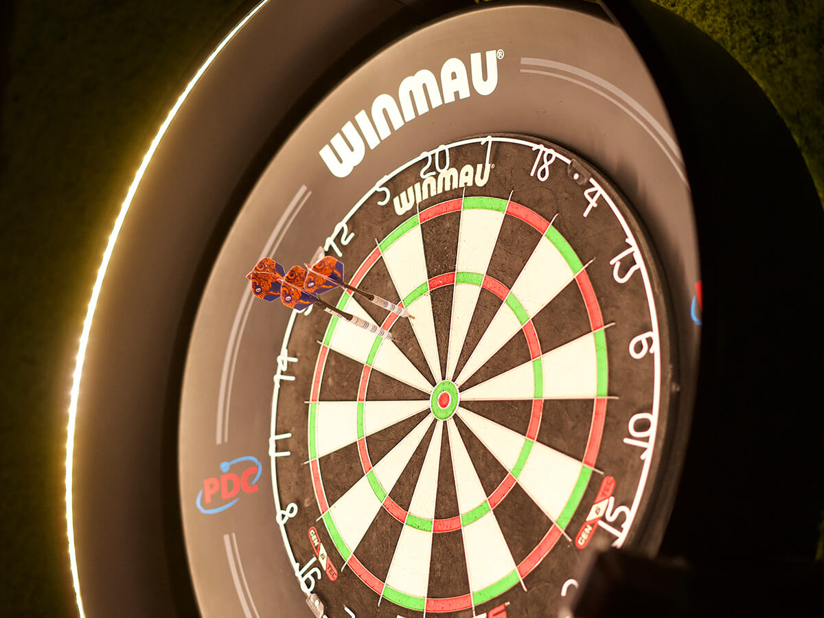 Speler gooit een pijl op de interactieve dartbaan